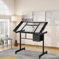 Rolling Drafting Table on Wheels, Painting Table Art Craft Desk Crafting Table with Tilting Transparent Tempered Glass Top, 2 Fabric Storage Drawers and 4 Wheels (Black)